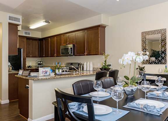 A kitchen with a dining table set for two.