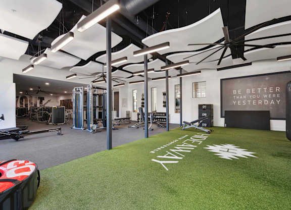 A gym with a green carpet and a punching bag.