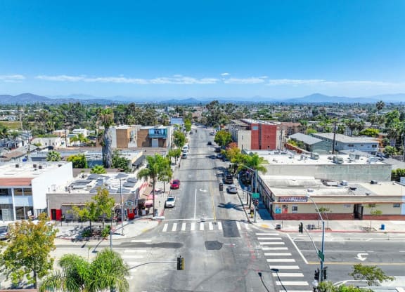 an aerial view of a city street with palm trees and buildings