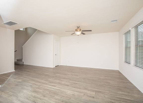 A room with a ceiling fan and light fixture.