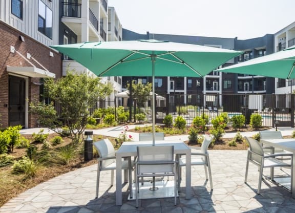 a patio with tables and chairs and umbrellas