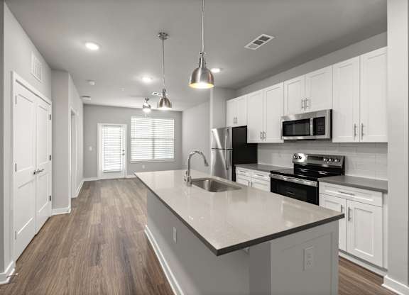A modern kitchen with white cabinets and a large island.