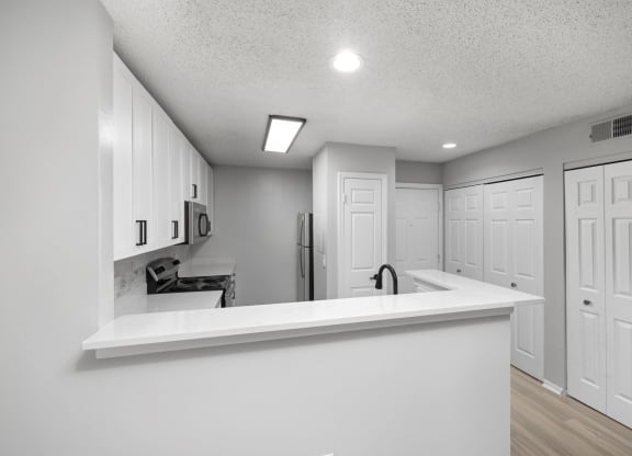 a kitchen with white cabinets and a white counter top