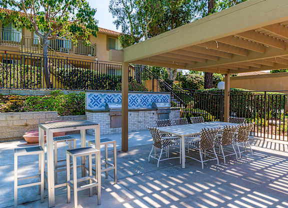 A patio with a table and chairs under a roof.