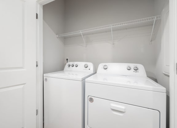 a washer and dryer in a white room with a white door