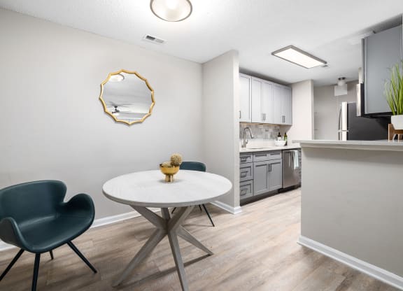 a dining room with a table and chairs and a kitchen with a counter at View at Lake Lynn, Raleigh, NC