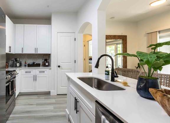 A modern kitchen with white cabinets and a stainless steel refrigerator.
