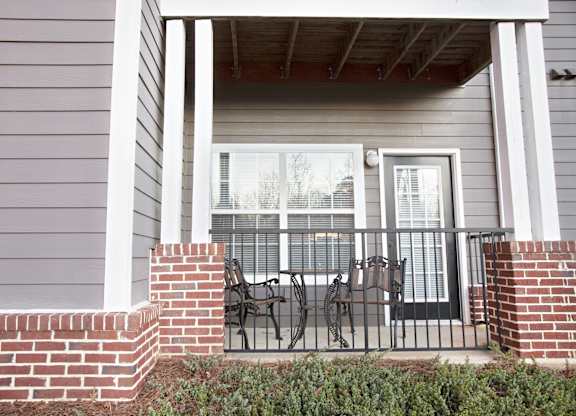 A house with a grey siding and a black metal railing.