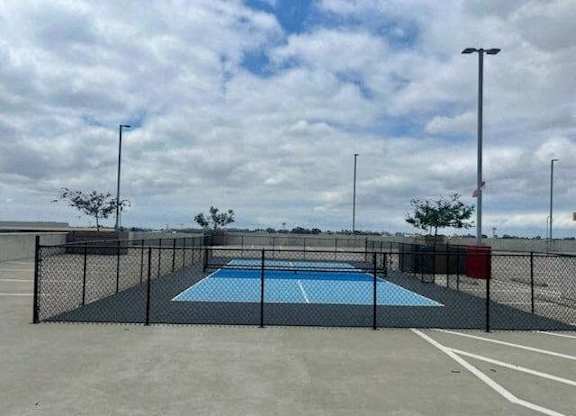 a rooftop pickleball court with a fence around it