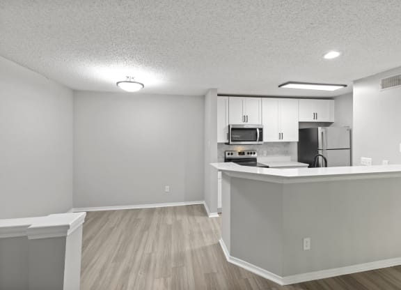 an open kitchen and living room with a counter top and