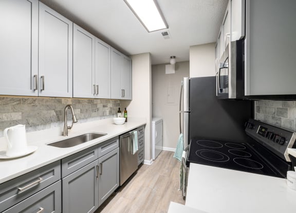 an empty kitchen with white cabinets and a black stove and refrigerator at View at Lake Lynn, Raleigh North Carolina