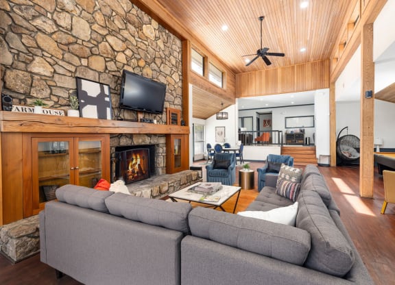 the living room has a large stone fireplace and a large couch