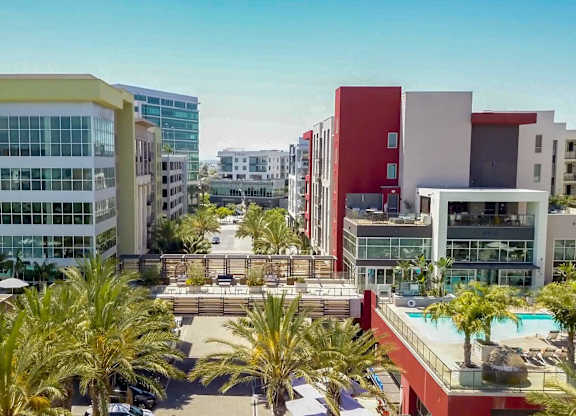 A modern building complex with a pool in the foreground.