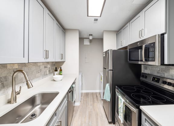 a kitchen with stainless steel appliances and white cabinets at View at Lake Lynn, Raleigh
