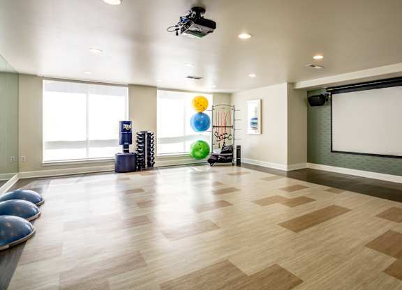 A room with a white screen and a wooden floor.