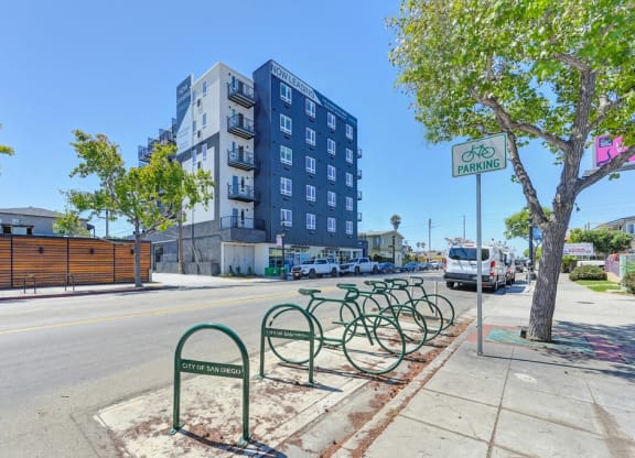 a row of bikes parked on a sidewalk next to a street