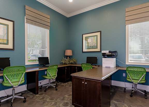 A room with blue walls and a desk with four chairs.
