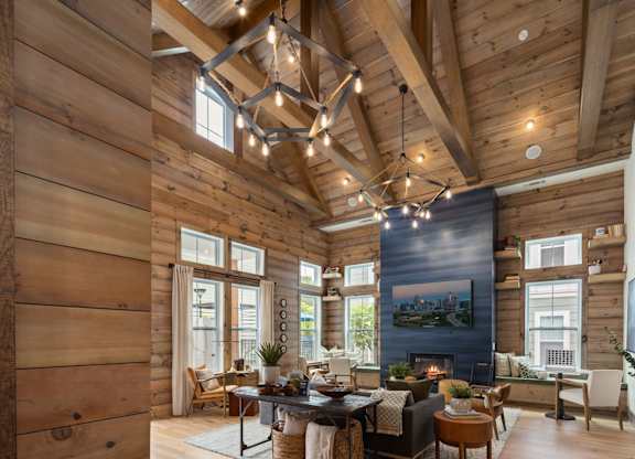 A wooden house with a large living room and a fireplace.