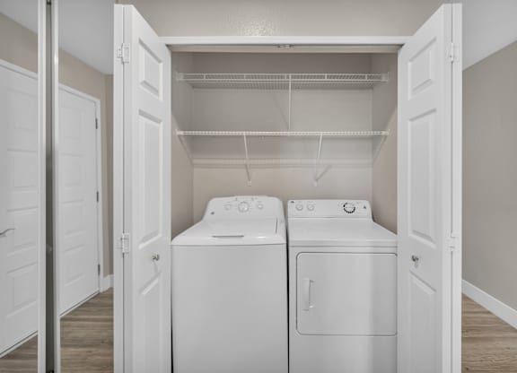 an empty laundry room with two washes and a dryer