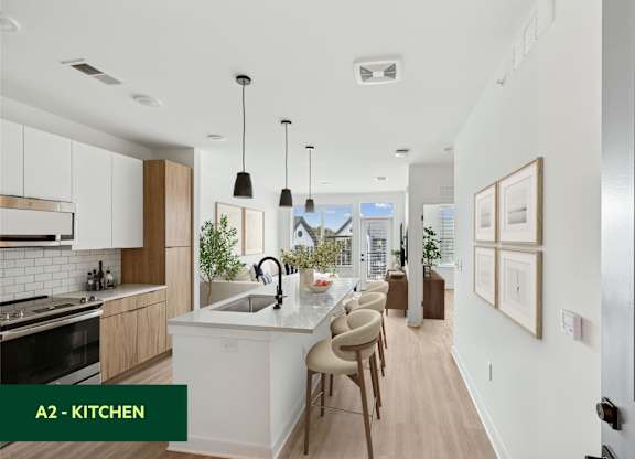 A modern kitchen with a large island and pendant lights.