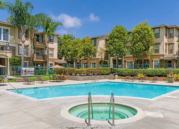 A swimming pool in front of apartment buildings.