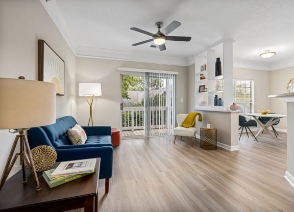a living room with a blue couch and a ceiling fan at Mariners Crossing, Raleigh