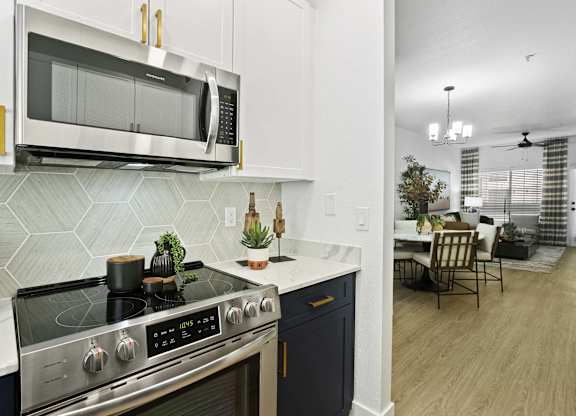 A modern kitchen with a stove top oven and microwave above it.