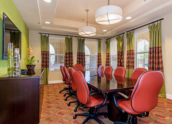 A conference room with a long table and chairs.