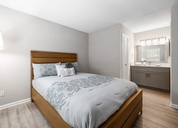 a bedroom with a bed and a bathroom with a sink at View at Lake Lynn, Raleigh North Carolina
