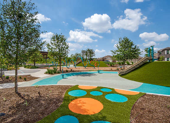 A playground with a slide and a tree.
