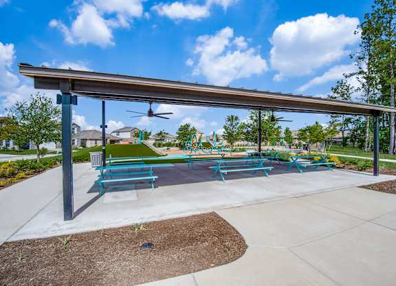 A park with a blue bench and a white canopy.