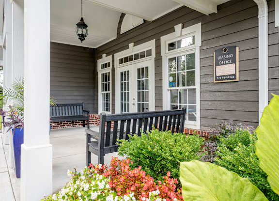 A grey house with a sign that says