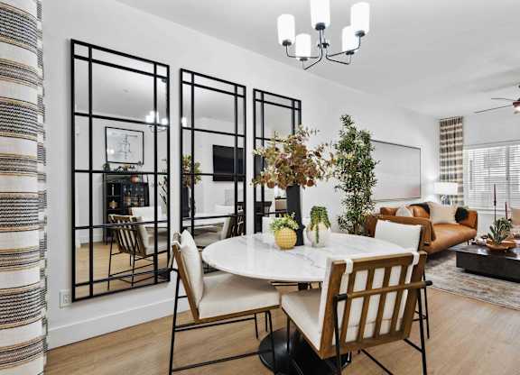 A dining room with a white table and chairs.
