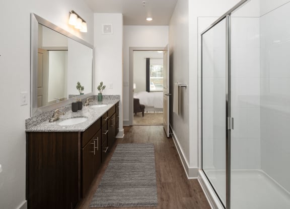 a bathroom with a shower and a sink and a mirror
