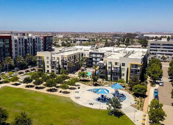 A large building complex with a pool in the middle of a grassy area.
