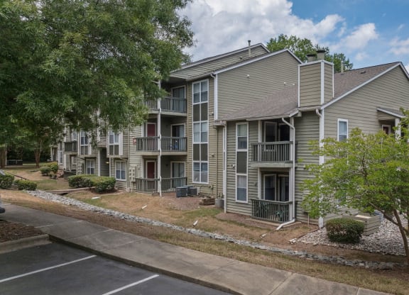 exterior view of an apartment building with sidewalks and trees