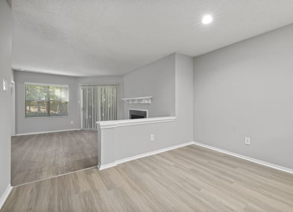 the living room and dining room of an empty house with a fireplace