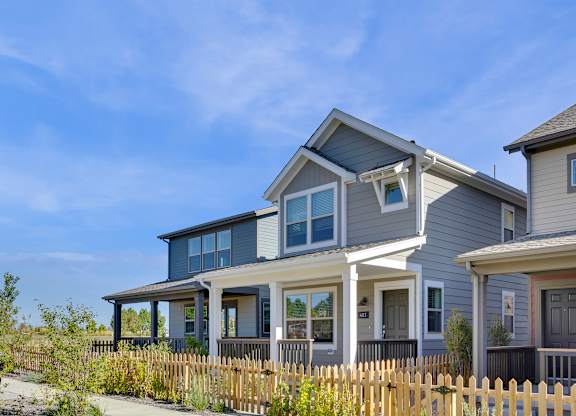 a blue house with white trim and a wooden fence