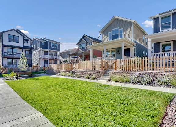 a row of houses with a yard and a sidewalk