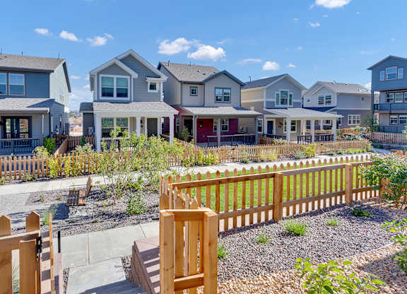 a row of houses with a yard and a wooden fence
