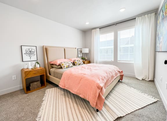 a bedroom with a bed and two windows