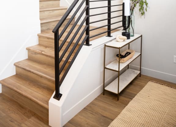 a stairway in a home with white walls and a black tire on the wall