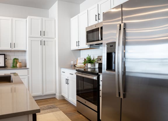 a kitchen with white cabinets and stainless steel appliances