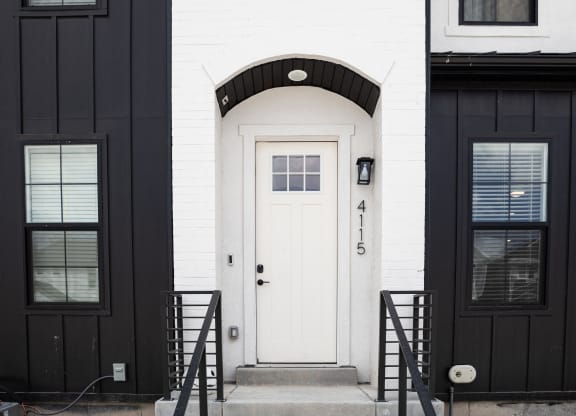 a black and white photo of a white house with a white door