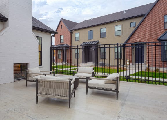 an outdoor patio with chairs and a fireplace