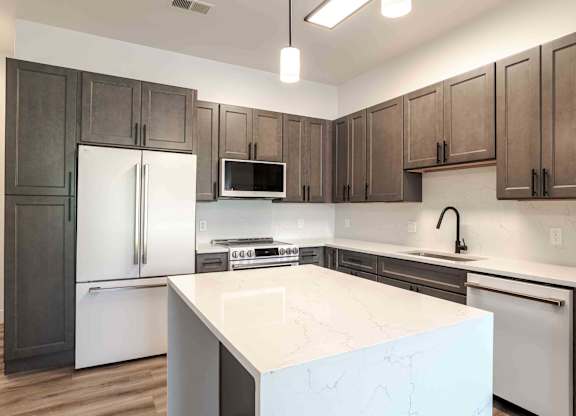 a kitchen with a large island and stainless steel appliances