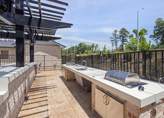 A patio with a grill and a table.