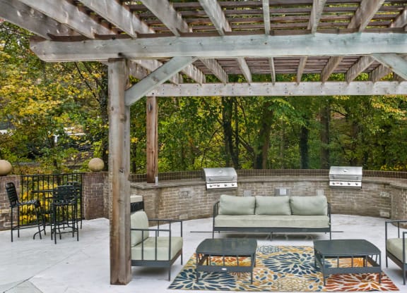 a patio with furniture and a wooden pergola