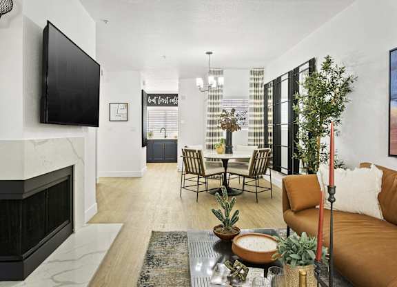 A living room with a fireplace and a television on the wall.