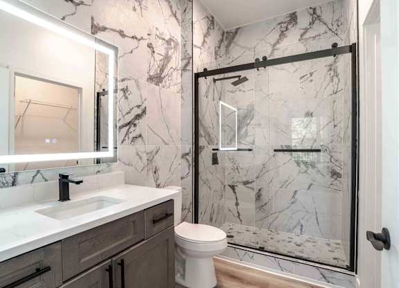 a bathroom with a shower and a sink and a toilet